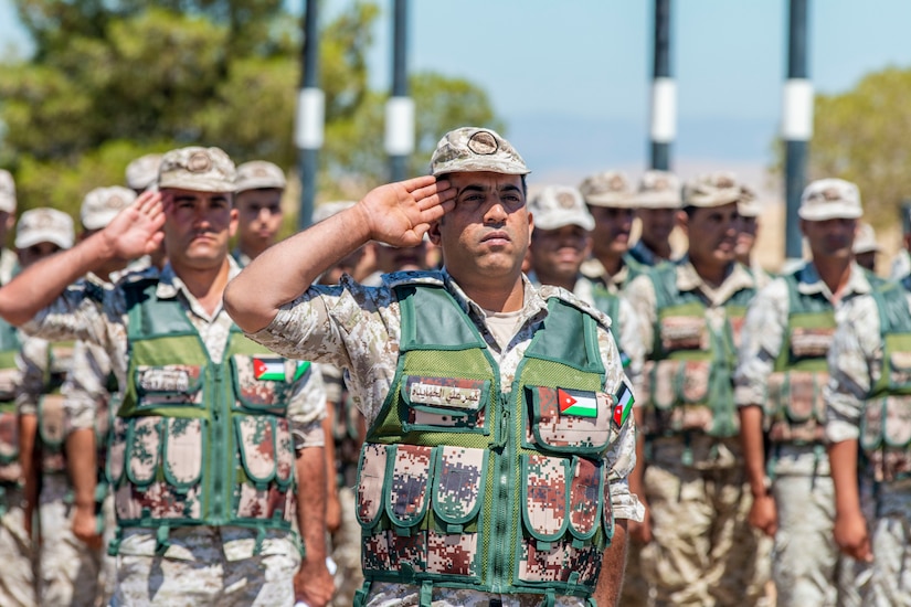 Jordan Border Guard Force Soldiers, with the 7th Mechanized Battalion, 48th Mechanized Brigade, render a salute to the Jordanian and American National Anthems during the Jordan Operational Engagement Program (JOEP) opening ceremony July 14, 2019. JOEP is a 14-week individual and collective training, as well as a military partnership between Jordan and America.