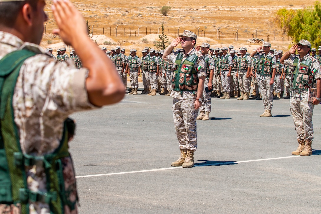 Jordan Border Guard Force Soldiers, with the 7th Mechanized Battalion, 48th Mechanized Brigade, render a salute to the Jordanian and American National Anthems during the Jordan Operational Engagement Program (JOEP) opening ceremony July 14, 2019. JOEP is a 14-week individual and collective training, as well as a military partnership between Jordan and America.