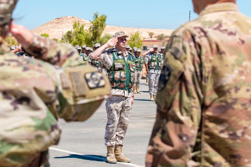 U.S. Army Soldiers and Jordan Border Guard Force Soldiers, with the 7th Mechanized Battalion, 48th Mechanized Brigade, render a salute to the Jordanian and American National Anthems during the Jordan Operational Engagement Program (JOEP) opening ceremony July 14, 2019. JOEP is a 14-week individual and collective training, as well as a military partnership between Jordan and America.