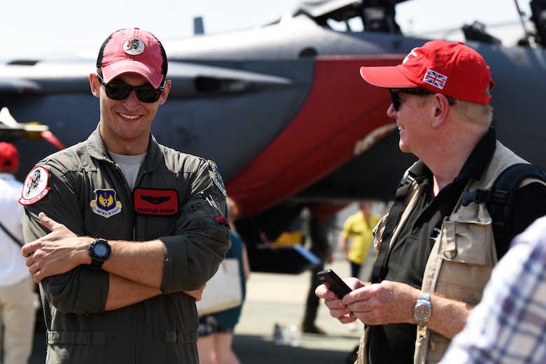 A 494th Fighter Squadron pilot talks to a local community member at Royal Air Force Marham’s annual Friends and Families Day July 25, 2019. The event is about recognizing the dedication of those working at RAF Marham and the support of their family and friends. (U.S. Air Force photo by Airman 1st Class Madeline Herzog)
