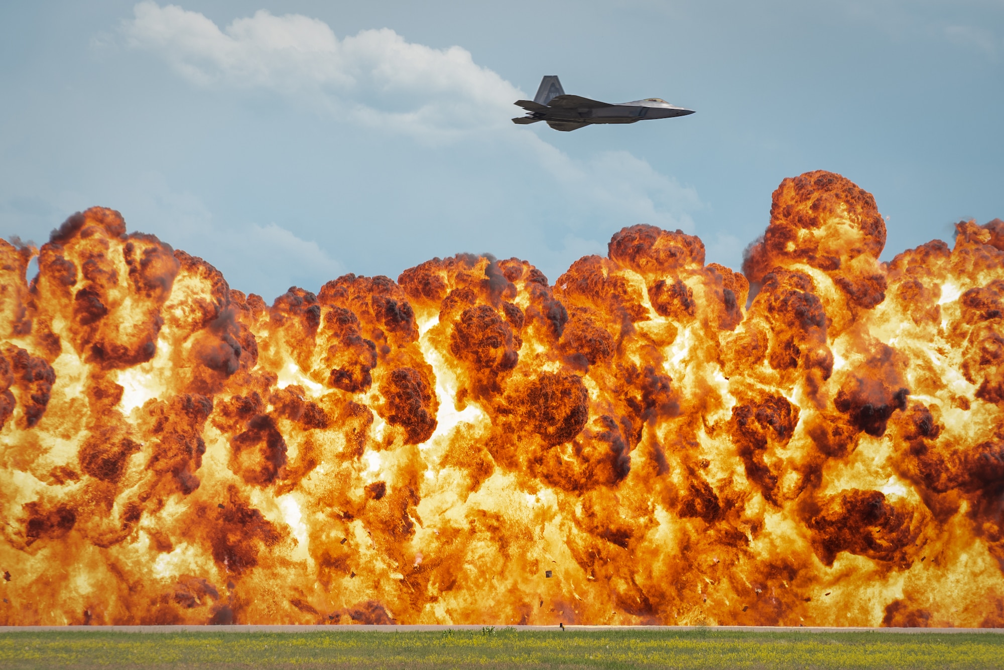 1,000-foot wall of fire explodes below the F-22 Raptor
