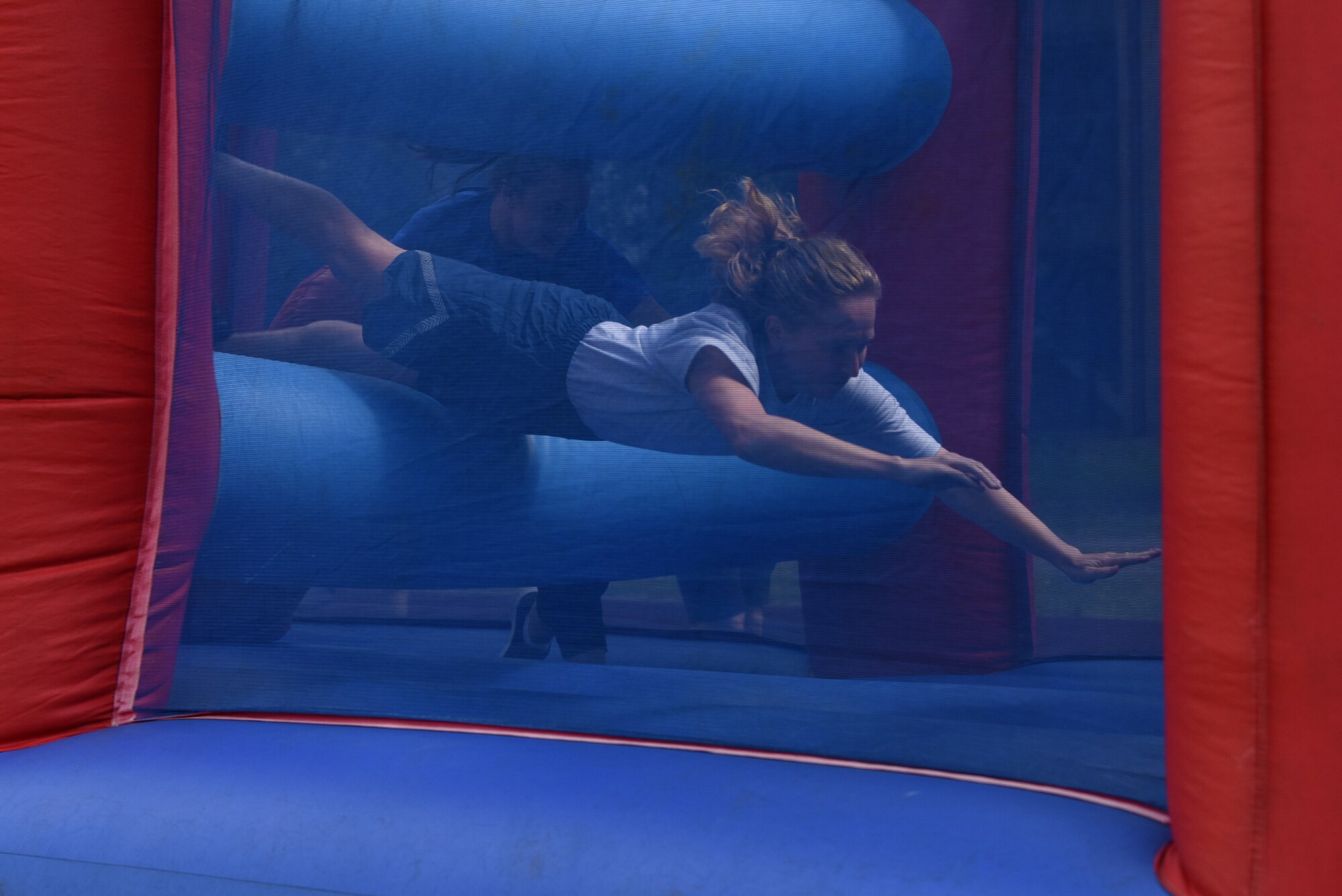 A U.S. Airman assigned to the 48th Mission Support Group dives through an inflatable obstacle course during the 48th MSG Olympics at Royal Air Force Lakenheath, England, July 22, 2019. Events included inflatable obstacle courses, tug of war, ultimate frisbee and more moral building events. (U.S. Air Force photo by Airman 1st Class Madeline Herzog)