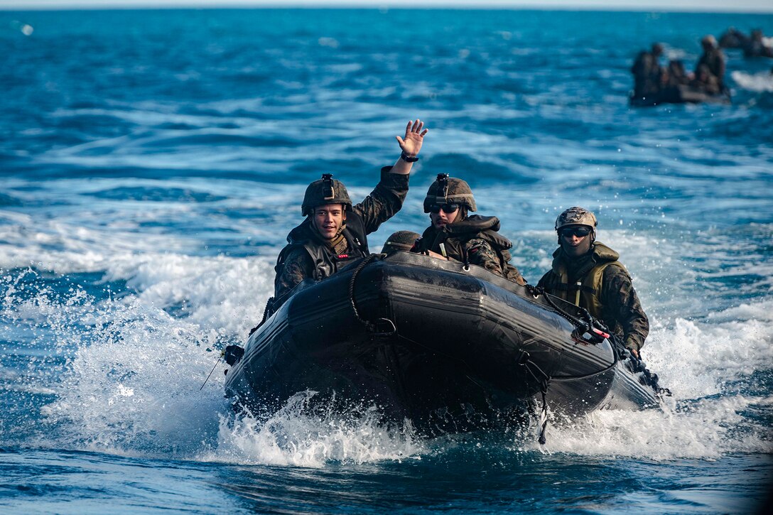 Marines travel in the ocean in a craft.