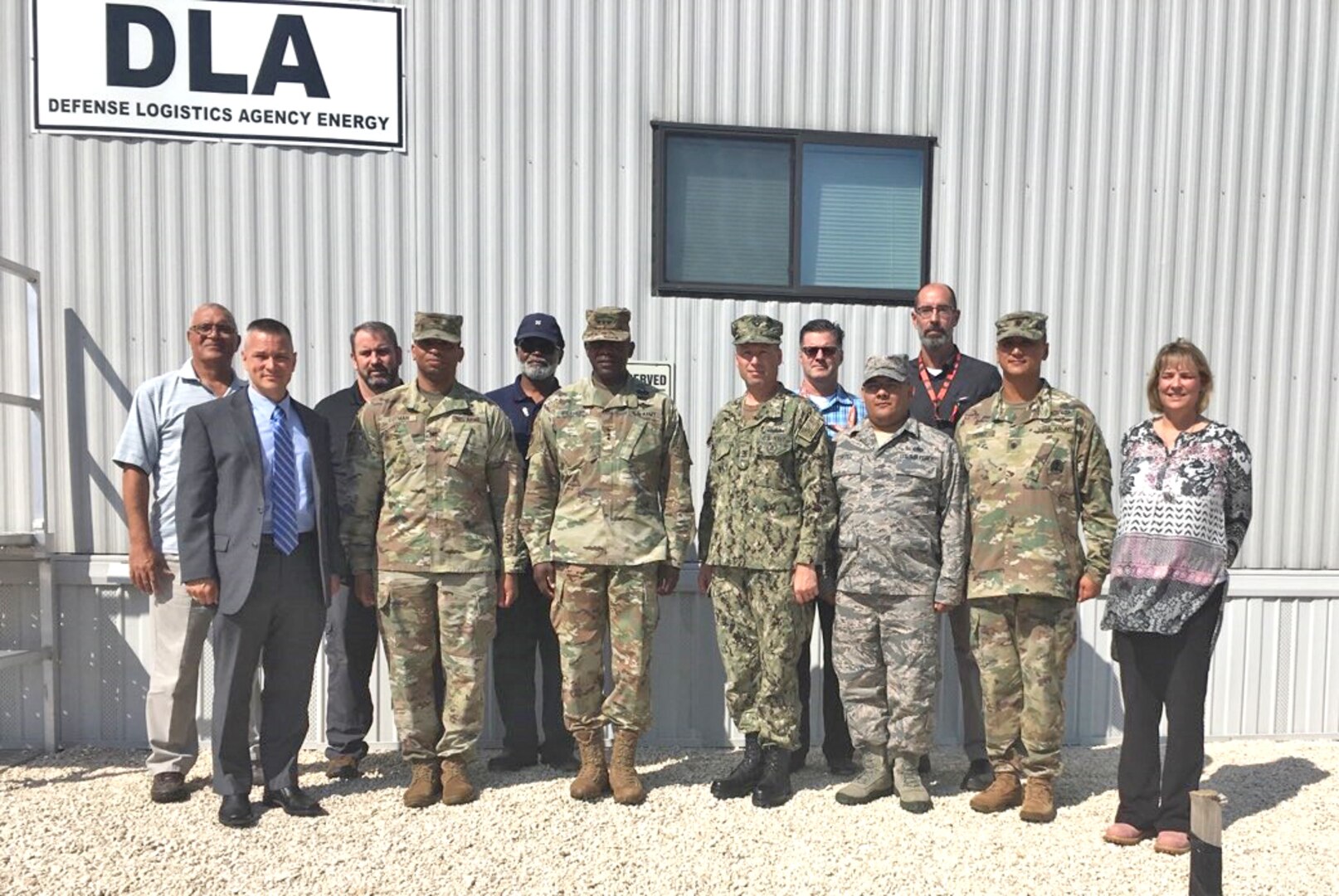 a group of military and civilian personnel pose for a photo