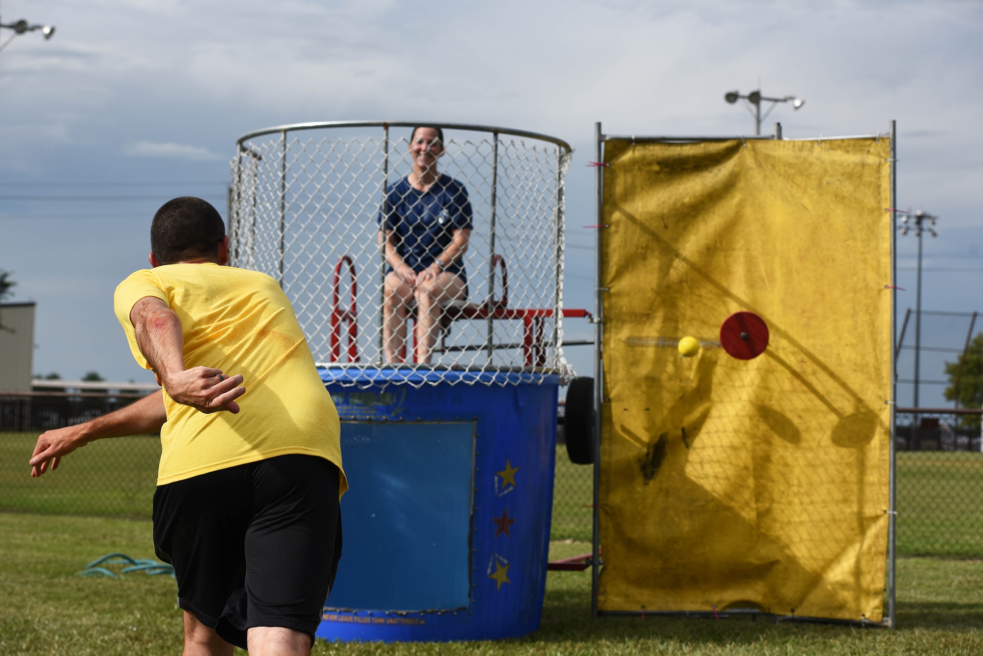 Staff Sgt. Jonathan Rosales, former 14th Flying Training Wing command chief executive assistant, throws a ball at the dunk tank while Col. Samantha Weeks, 14th Flying Training Wing commander, sits on a dunk stool during BLAZE Fest July 3, 2019 on Columbus Air Force Base, Miss. A variety of activities and contests were held throughout the festival for attendees to participate in. (U.S. Air Force photo by Senior Airman Keith Holcomb)