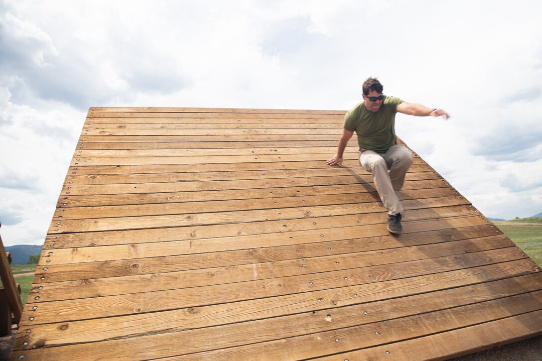 A civilian walks on a wood structure.