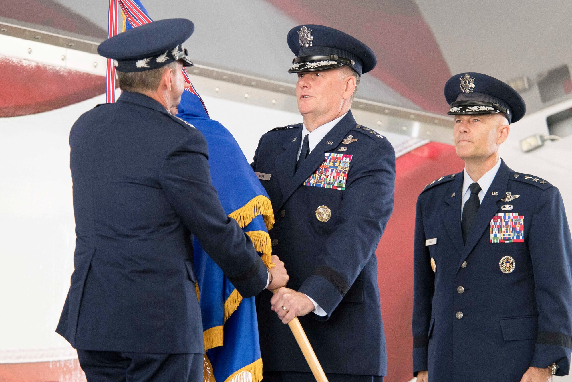 U.S. Air Force Chief of Staff Gen. David L. Goldfein, left, presents the Air Education and Training Command guidon to Lt. Gen. Brad Webb, new commander of AETC, during a change of command ceremony July 26, 2019, at Joint Base San Antonio-Randolph, Texas. At right is U. S. Air Force Lt. Gen. Steve Kwast, outgoing AETC commander.  Webb, a 1984 graduate of the U.S. Air Force Academy, is a command pilot with more than 3,700 flying hours, including 117 combat hours in Afghanistan, Iraq and Bosnia. (U.S. Air Force photo by Sean M. Worrell)