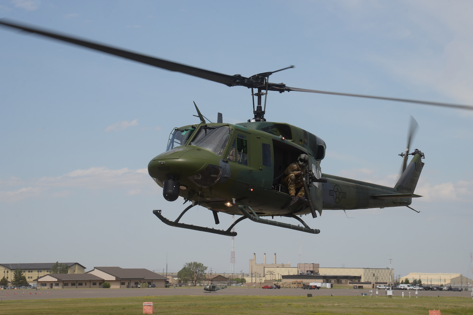 A UH-1N helicopter carrying tactical response force members chase a vehicle during a training event July 24, 2019, at Malmstrom Air Force Base, Mont.