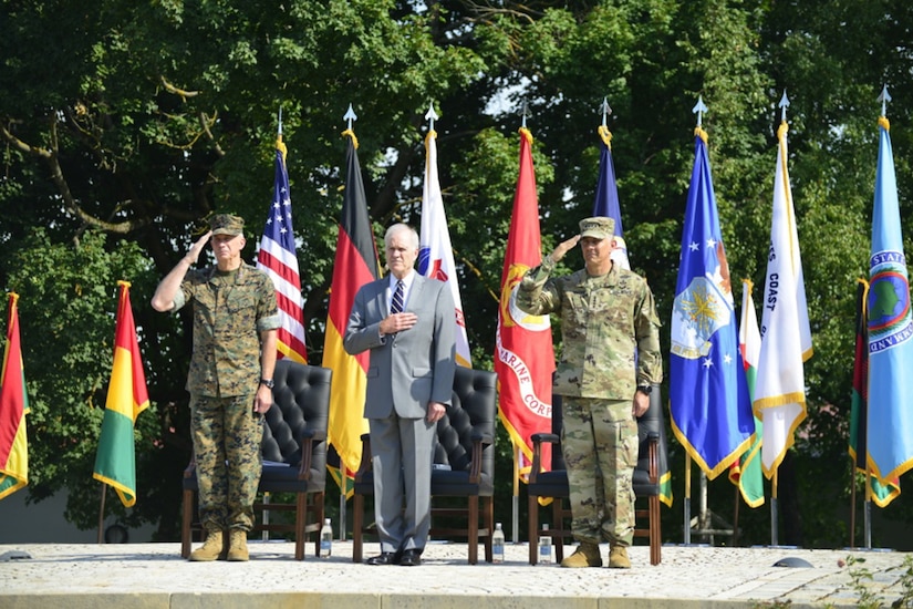 Official party salutes a joint color guard.