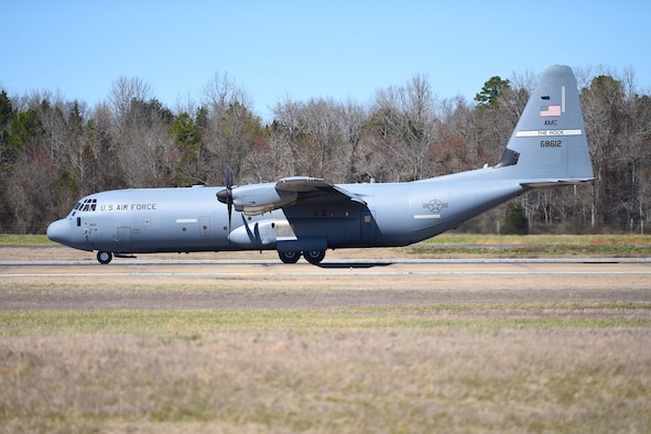 A big gray airplane lands on the runway.