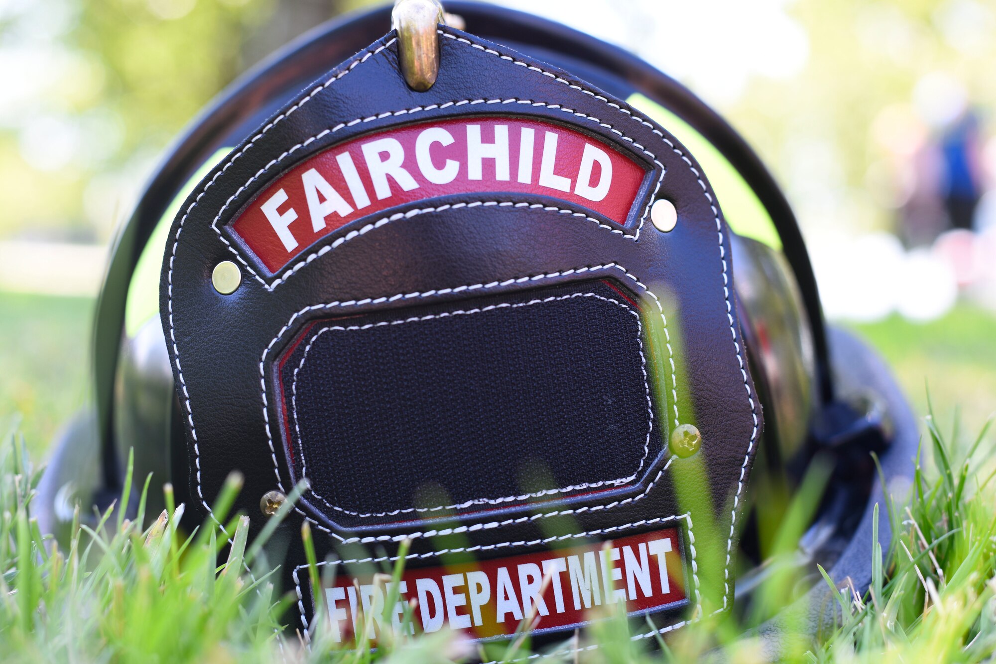 A firefighter’s helmet from Fairchild’s fire department rests in the grass during the Summer Youth Fair at Fairchild Air Force Base, Washington, July 25, 2019. Members from Fairchild’s 92nd Civil Engineer Squadron Fire Department, Explosive Ordnance Disposal team, 92nd Security Forces Squadron and 92nd Medical Group provided activities and educational exhibits. (U.S. Air Force photo by Airman 1st Class Lawrence Sena)