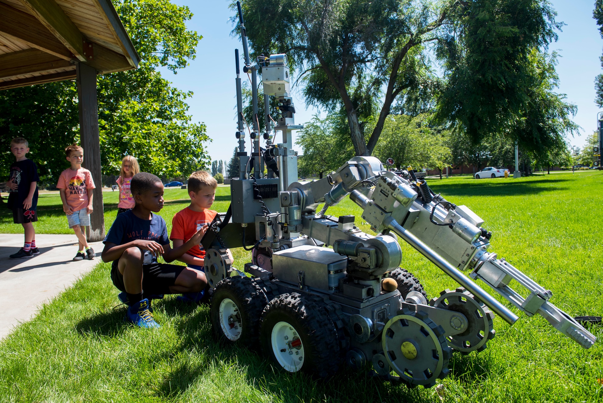 Children with the Fairchild Youth Center explore an explosive ordnance disposal robot from the 92nd Civil Engineer Squadron Explosive Ordnance Disposal flight, during the Summer Youth Fair at Fairchild Air Force Base, Washington, July 25, 2019. Members from Fairchild’s 92nd Civil Engineer Squadron Fire Department, Explosive Ordnance Disposal team, 92nd Security Forces Squadron and 92nd Medical Group provided activities and educational exhibits. (U.S. Air Force photo by Airman 1st Class Lawrence Sena)