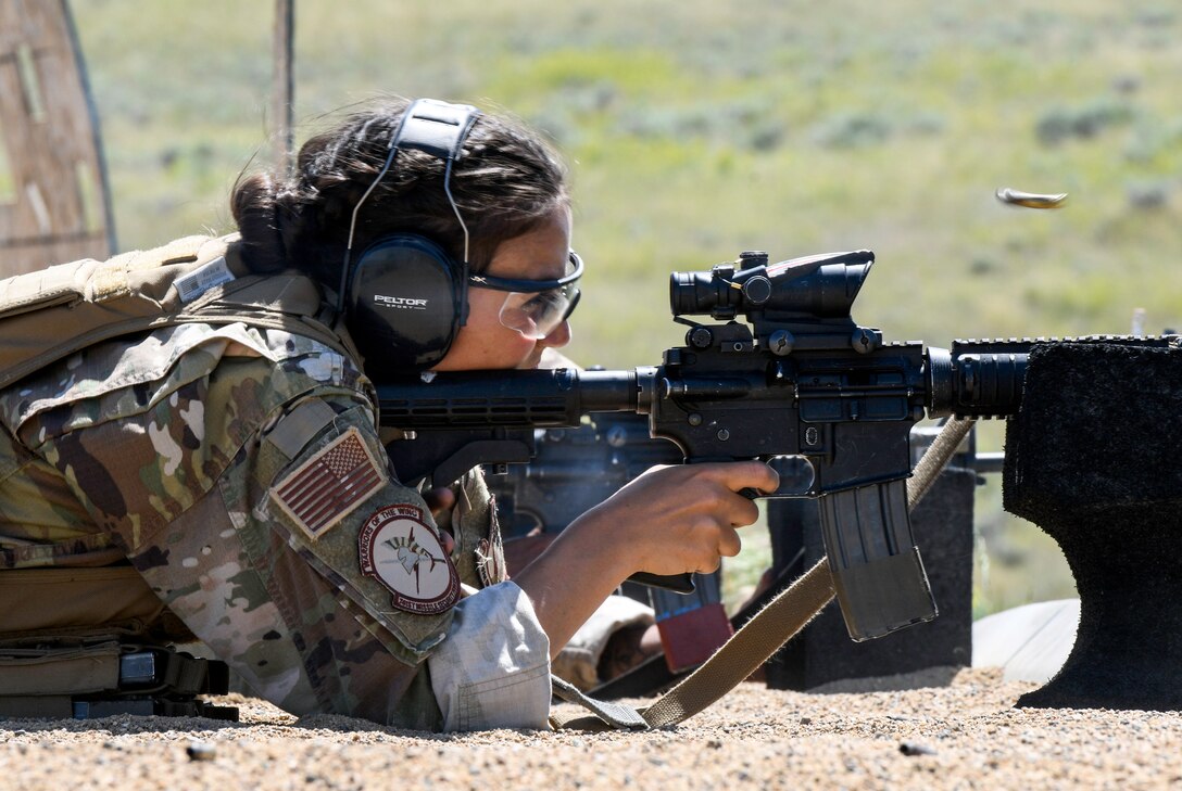 An airman fires a rifle from the ground.