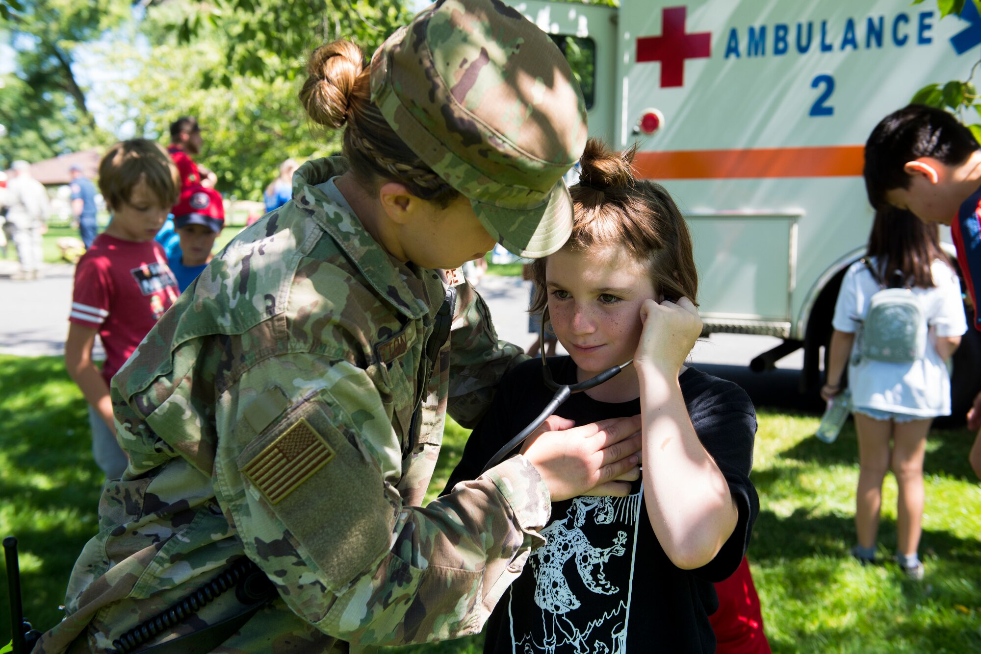 U.S. Air Force Staff Sgt. Sara Huston, 92nd Health Care Operations Squadron medical technician, shows a kid how to use a stethoscope during the Summer Youth Fair at Fairchild Air Force Base, Washington, July 25, 2019. Approximately 100 children from across Fairchild participated in the fair. (U.S. Air Force photo by Airman 1st Class Lawrence Sena)