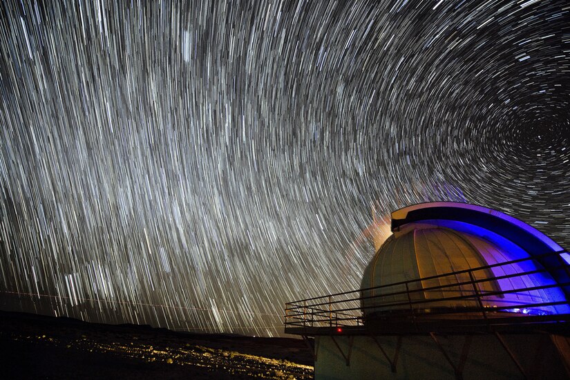 Stars illuminate the sky over a domed structure.
