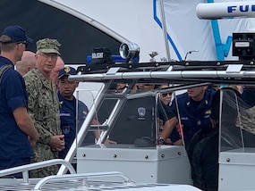Military personnel board a boat.