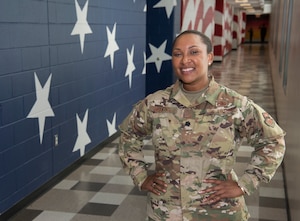Lt. Col. Jeurney Meekins, 321 st Training Squadron former commander, poses in front of a mural of the American flag July 17, 2019, at Joint Base San Antonio-Lackland, Texas.