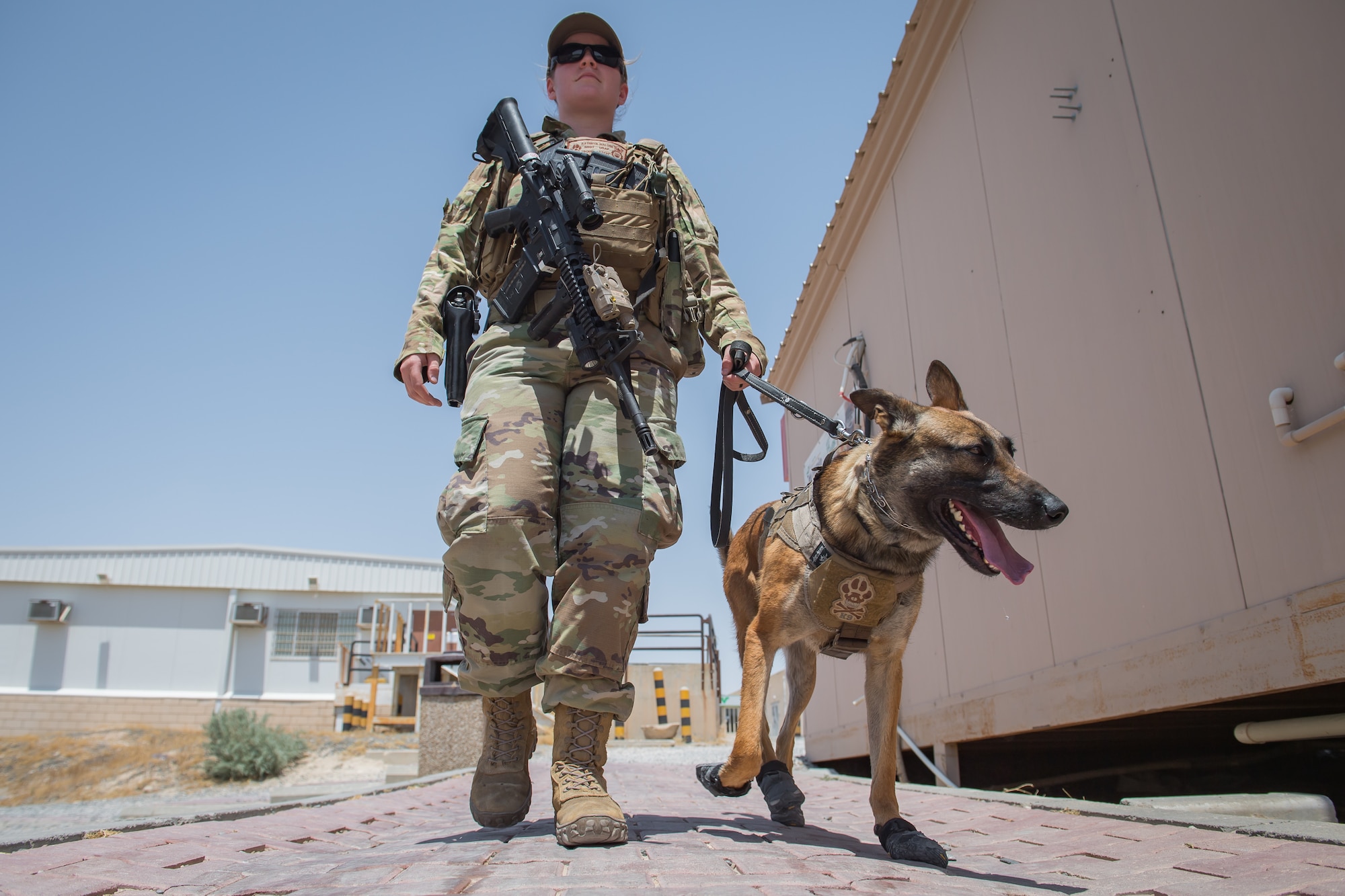 U.S. Air Force Staff Sgt. Kathyrn Malone, 386th Expeditionary Security Forces Squadron military working dog handler, walks her MWD, Uurska, while conducting a foot patrol at Ali Al Salem Air Base, Kuwait, July 24, 2019. Malone and Uurska are both deployed from the 55th Security Forces Squadron, Offutt Air Force Base, Neb. (U.S. Air Force photo by Tech. Sgt. Daniel Martinez)