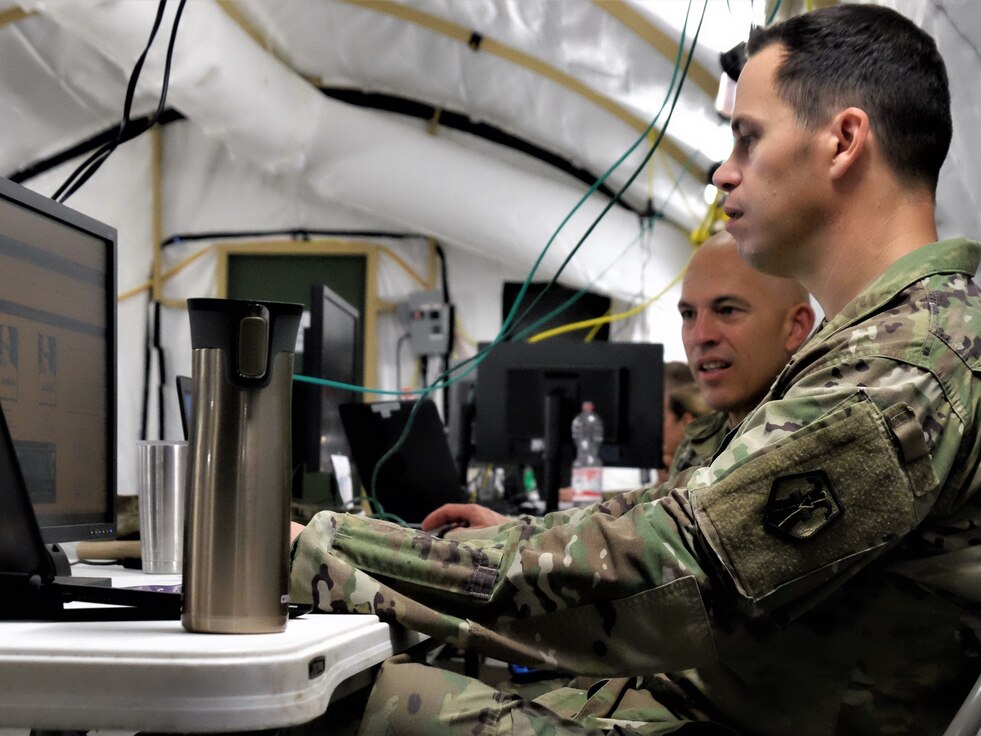 KAISERSLAUTERN, Germany – Maj. Jason M. Ruiz (front), the G3 plans officer, and Lt. Col. Scott A. Silvester, the G3 force modernization officer, both part of the exercise White Cell, develop the exercise scenario in order to test the unit’s ability to conduct the military decision making process  during the 7th MSC’s Annual Training at Daenner Kaserne May 30 to June 4, 2019. (US Army photo by Sgt. Daniel J. Friedberg, 7th MSC Public Affairs Office)