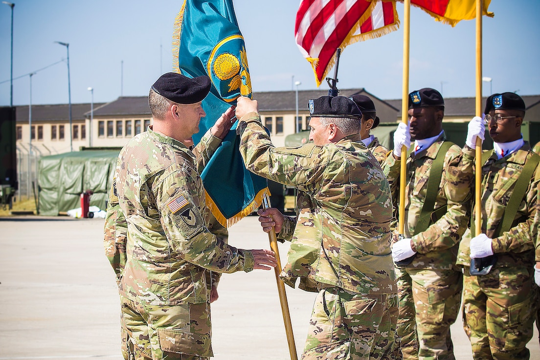 Lt.  Col. Scott Boyington, outgoing commander, Army Field Support Battalion - Mannheim, passes the battalion colors to Col. Grant L. Morris, 405th AFSB commander, at a change of command ceremony,  at Coleman Worksite in Mannheim, Germany, July 2.