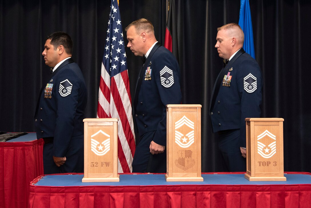 U.S. Air Force Master Sgt. Samuel Jalomo, 52nd Security Forces Squadron operations NCO in charge, left, Chief Master Sgt. James Andrews, 52nd Aircraft Maintenance Squadron superintendent, center, and Senior Master Sgt. Aaron Townsend, 52nd Maintenance Squadron lead production superintendent, conduct a candle lighting ceremony during a senior NCO induction ceremony at Spangdahlem Air Base, Germany, July 26, 2019. The three candle pillars symbolize progression through the top tier of the enlisted ranks. (U.S. Air Force photo by Airman 1st Class Valerie Seelye)