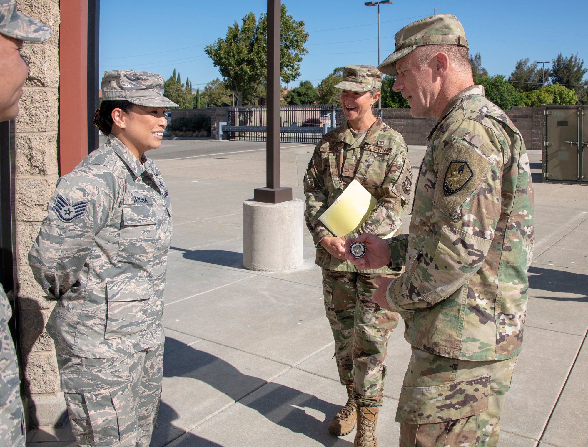 U.S. Army Gen. Steve Lyons, right, U.S. Transportation Command commander, Scott Air Force Base, Illinois, recognizes Staff Sgt. Cherielyn Amaba, 60th Diagnostics and Therapeutics Squadron noncommissioned officer in charge of mammography, as a star performer, July 24, 2019 at Travis Air Force Base, California. Lyons had the opportunity to interact with Travis Airmen and tour several units while on the base visit. (U.S. Air Force photo by Heide Couch)