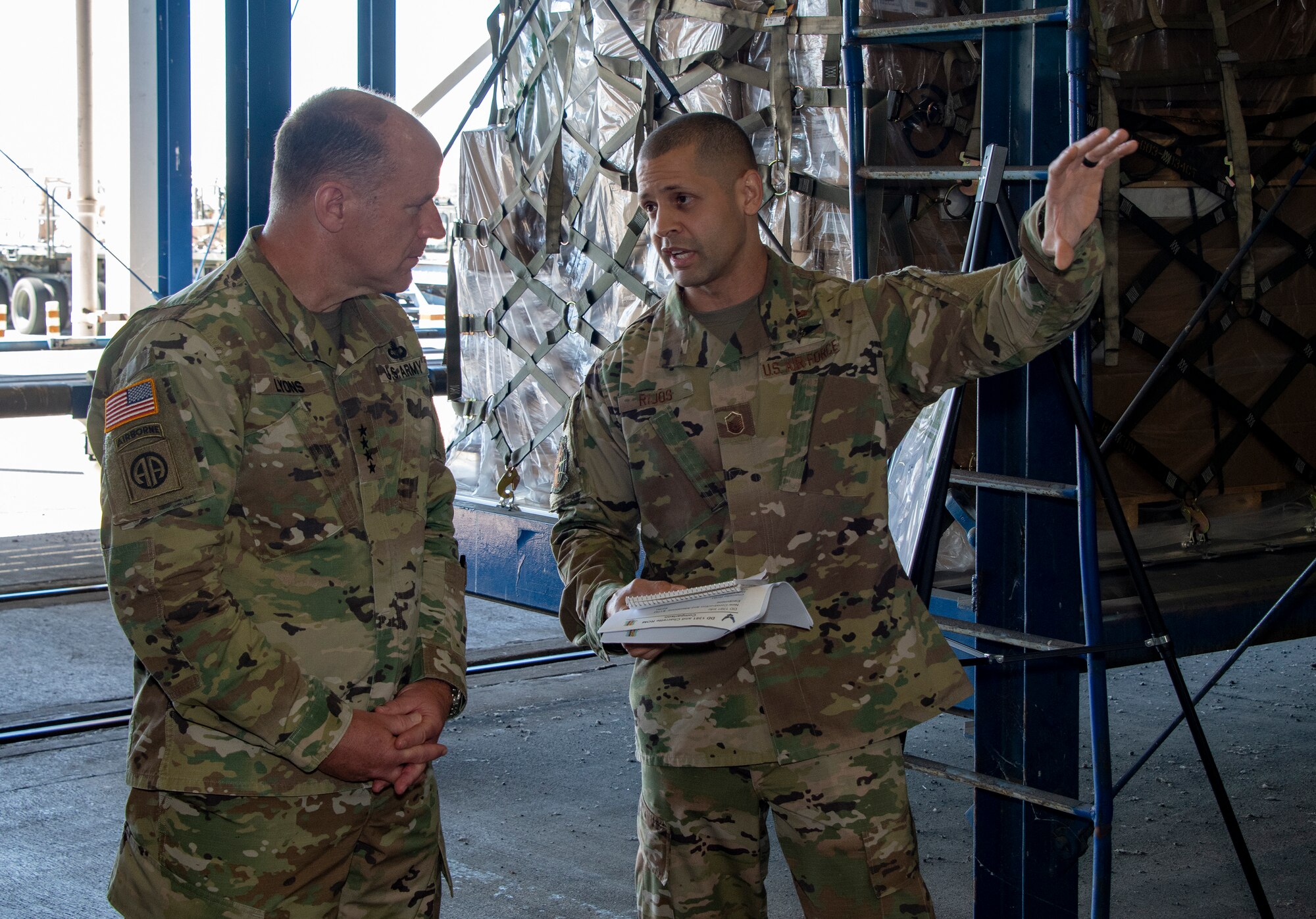 U.S. Army Gen. Steve Lyons, left, U.S. Transportation Command commander, Scott Air Force Base, Illinois, listens to Master Sgt. Juan Rijos, 60th Aerial Port Squadron operations flight superintendent, during a visit to the 60th APS warehouse, July 24, 2019 at Travis Air Force Base, California. Lyons had the opportunity to interact with Travis Airmen and tour several units while on the base visit. (U.S. Air Force photo by Heide Couch)