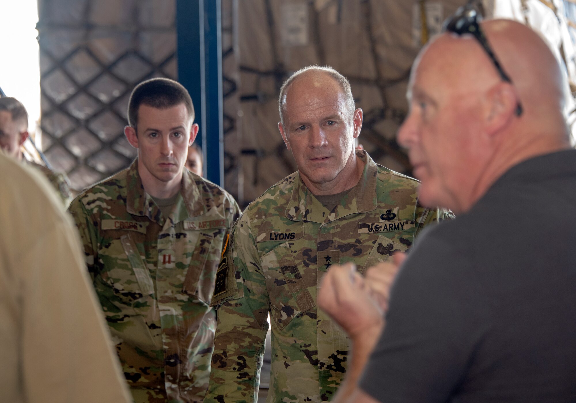 U.S. Army Gen.l Steve Lyons, center, U.S. Transportation Command commander, Scott Air Force Base, Illinois, listens to John Buchanan, right, 60th Aerial Port Squadron transportation operations officer, during a visit to the 60th APS warehouse, July 24, 2019 at Travis Air Force Base, California. Lyons had the opportunity to interact with Travis Airmen and tour several units while on the base visit. (U.S. Air Force photo by Heide Couch)