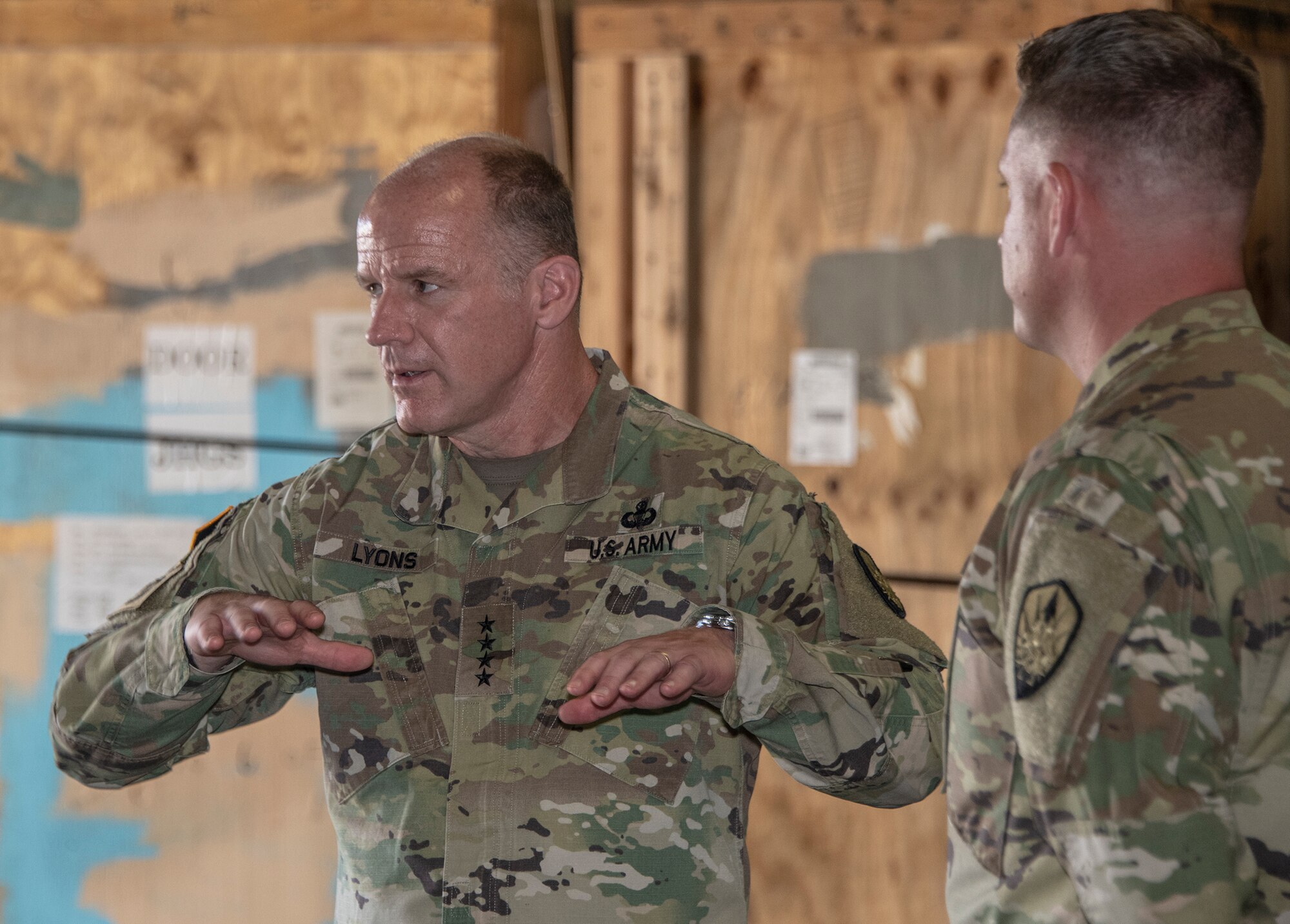 U.S. Army Gen.l Steve Lyons, U.S. Transportation Command commander, Scott Air Force Base, Illinois, speaks to members of the Defense Threat Reduction Agency during a visit to the 60th Aerial Port Squadron warehouse, July 24, 2019 at Travis Air Force Base, California. Lyons had the opportunity to interact with Travis Airmen and tour several units while on the base visit. (U.S. Air Force photo by Heide Couch)