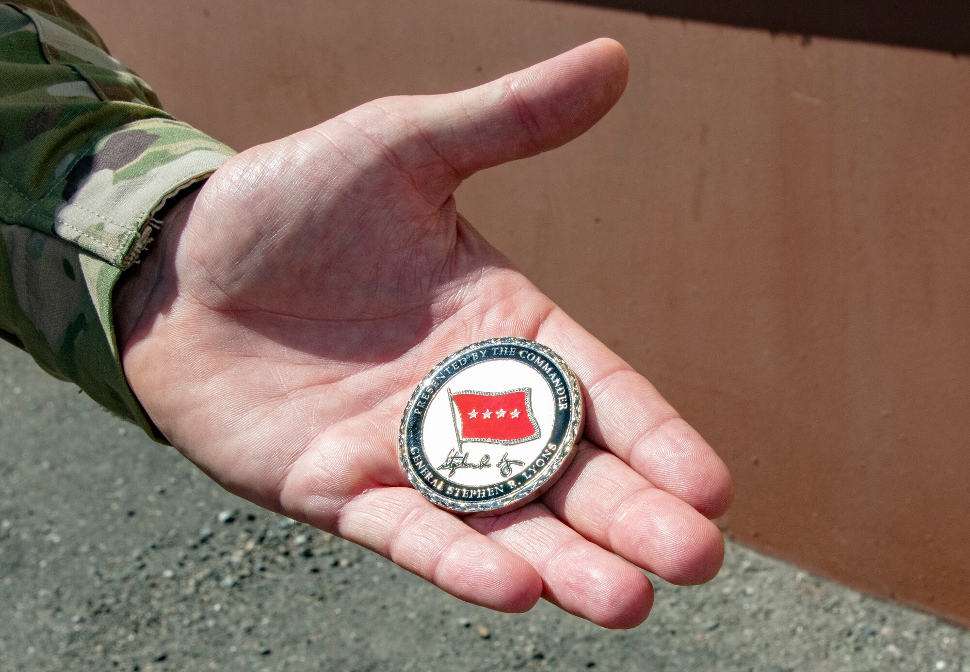 U.S. Air Force Senior Master Sgt. Corydon Coombs, Defense Threat Reduction Agency courier, displays the coin presented to him by U.S. Army Gen.l Steve Lyons, U.S. Transportation Command commander, Scott Air Force Base, Illinois, during a visit to the 60th Aerial Port Squadron warehouse, July 24, 2019 at Travis Air Force Base, California. Lyons had the opportunity to interact with Travis Airmen and tour several units while on the base visit. (U.S. Air Force photo by Heide Couch