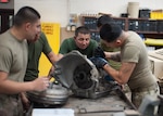 Members of the Armed Forces from the Republic of Kazakhstan and the Arizona Army National Guard dismantle the transmission from a M998A2 Series High Mobility Multipurpose Wheeled Vehicle (HMMWV) during a State Partnership Program vehicle maintenance exchange at the Papago Park Military Reservation July 16. During this week-long maintenance exchange, wheeled vehicle mechanics from both countries explained how they conduct fleet maintenance operations, parts and tools supply logistics and manage personnel and facilities that support maintenance functions.