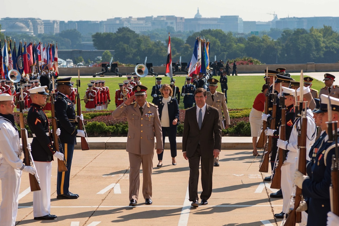 Officials walk up the walkway to the Pentagon.