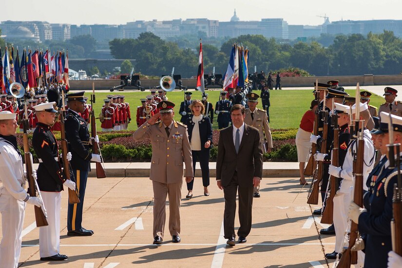 Officials walk up the walkway to the Pentagon.