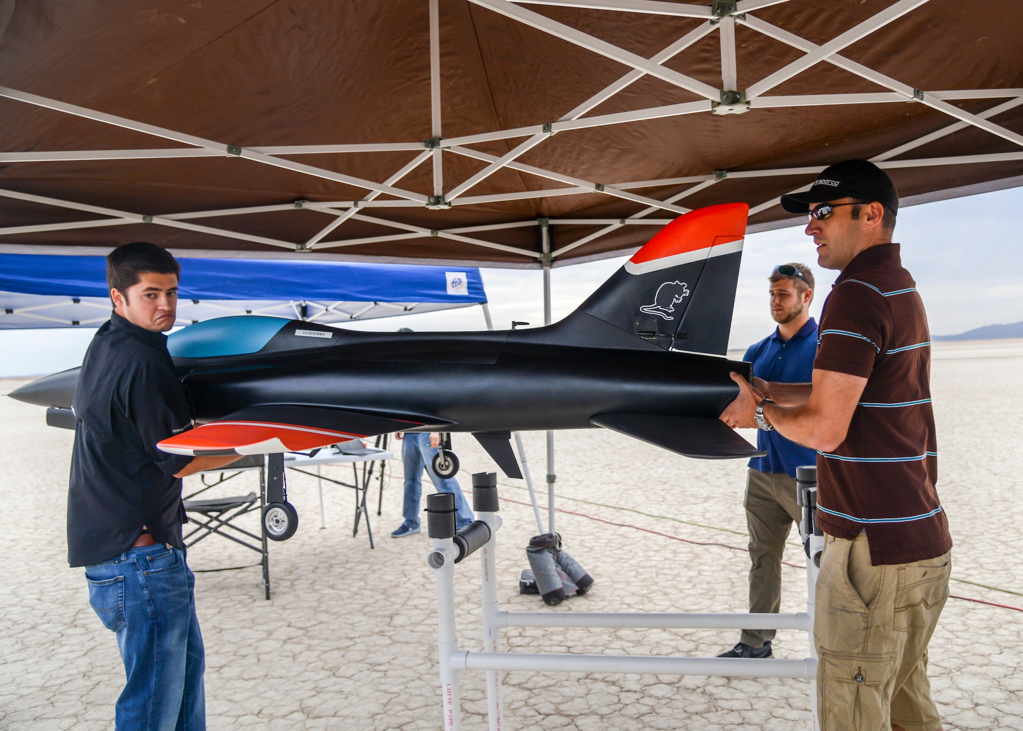 Engineers lift an unmanned jet-powered aircraft into position for a flight test at Edwards Air Force Base, Calif., July 25. (U.S. Air Force photo by Giancarlo Casem)
