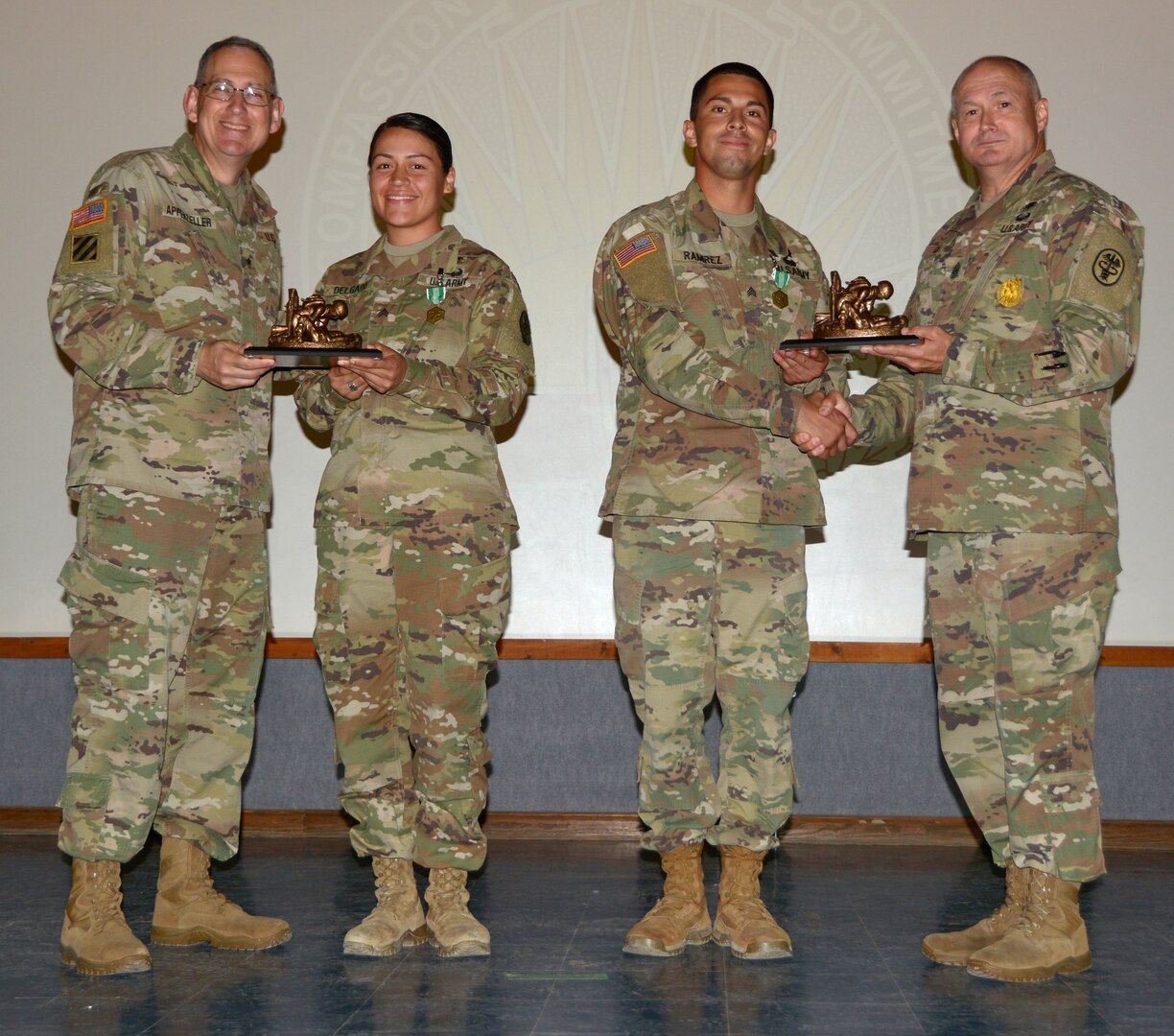 Brig. Gen. Ned Appenzeller (left) and Command Sgt. Maj. Joseph Cecil (right) hand trophies to Sgt. Samantha Delgado (center left) and Sgt. Kevin Ramirez (center right) at the Regional Health Command-Central Best Medic ceremony at Joint Base San Antonio-Camp Bullis. Delgado and Ramirez will represent Brooke Army Medical Center and Regional Health Command-Central at the Army Medicine Best Medic Competition in the fall.
