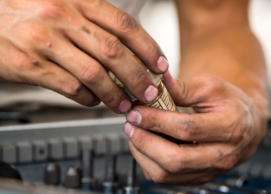 An Airman from the 75th Aircraft Maintenance Unit opens a bottle of screws during a sortie surge exercise, July 24, 2019, at Moody Air Force Base, Ga. The exercise was conducted to determine Airmen's abilities to perform effectively while generating combat or training sorties at an accelerated rate. Throughout the four-day surge, pilots and maintainers completed 131 sorties spanning approximately 152 flying hours. (U.S. Air Force photo by Airman 1st Class Eugene Oliver)