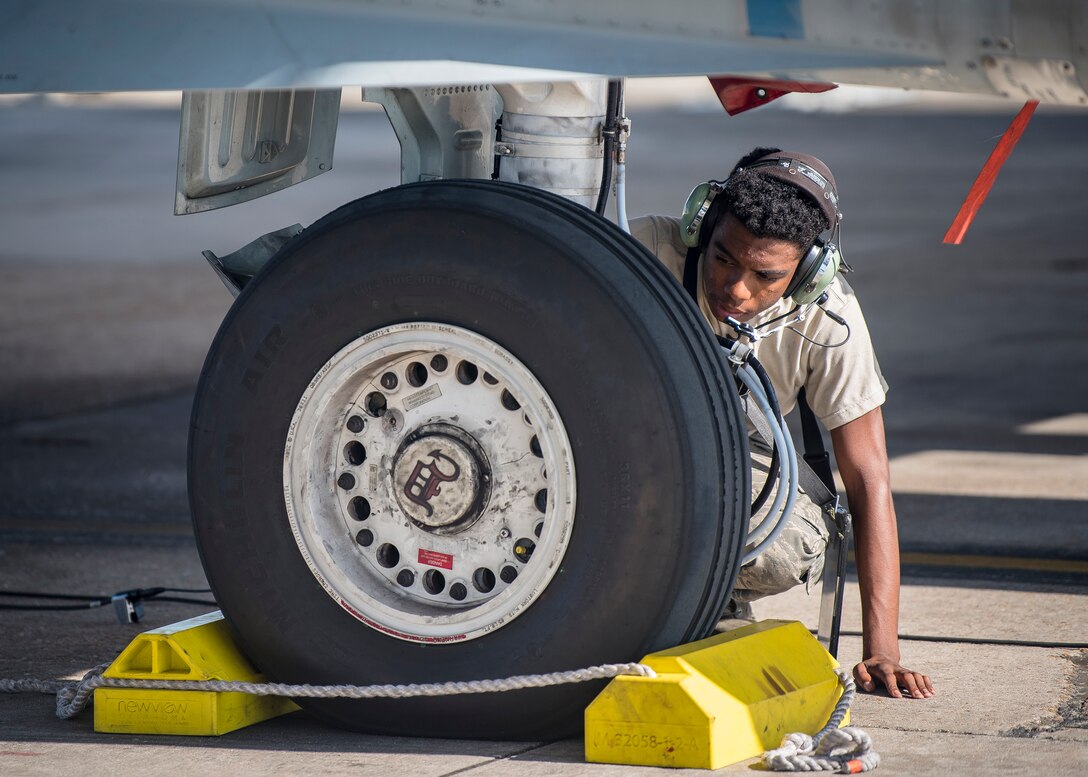 Airman 1st Class Kezrion Mims, 75th Aircraft Maintenance Unit crew chief, inspects the landing gear of an A-10C Thunderbolt II during a sortie surge exercise, July 24, 2019, at Moody Air Force Base, Ga. The exercise was conducted to determine Airmen's abilities to perform effectively while generating combat or training sorties at an accelerated rate. Throughout the four-day surge, pilots and maintainers completed 131 sorties spanning approximately 152 flying hours. (U.S. Air Force photo by Airman 1st Class Eugene Oliver)