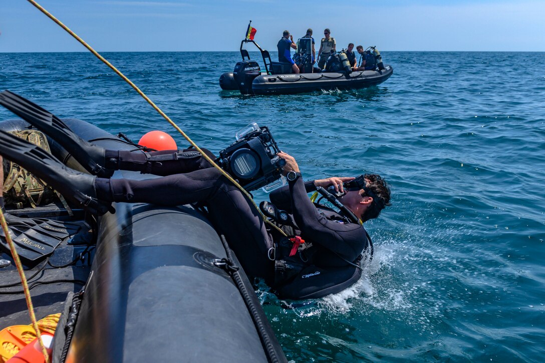 A sailor dives into water.