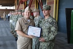 Rear Adm. Tom Anderson presents a Navy Afloat Maintenance Training Strategy certificate to Machinist Mate Second Class Paul Lewis at Puget Sound Naval Shipyard & Intermediate Maintenance Facility Everett Detachment during an all-hands presentation in Everett, Washington. Anderson is Commander, Navy Regional Maintenance Center and Naval Sea Systems Deputy Commander, Ship Maintenance and Modernization (SEA 21) and visited Northwest Regional Maintenance Center (NWRMC) on Jul 22.