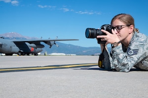 Staff Sgt. Heather Heiney, a 302nd Airlift Wing photojournalist, takes photos on the flight line at Peterson Air Force Base, Colorado, July 3, 2019. (U.S. Air Force photo by Tech. Sgt. Frank Casciotta)