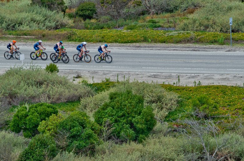 POINT MUGU, Calif. (June 22, 2019) Competitors, including Capt. John Bierman, 21st Space Warning Squadron crew commander (far right)  participate in the bicycle portion of the Armed Forces Triathlon held at Naval Base Ventura County in Point Mugu, California. The triathlon included a 1.5-kilometer swim, 40-kilometer bike ride and a 10-kilometer run. (U.S. Navy photo by Mass Communication Specialist 2nd Class Jesse L. Gonzalez).