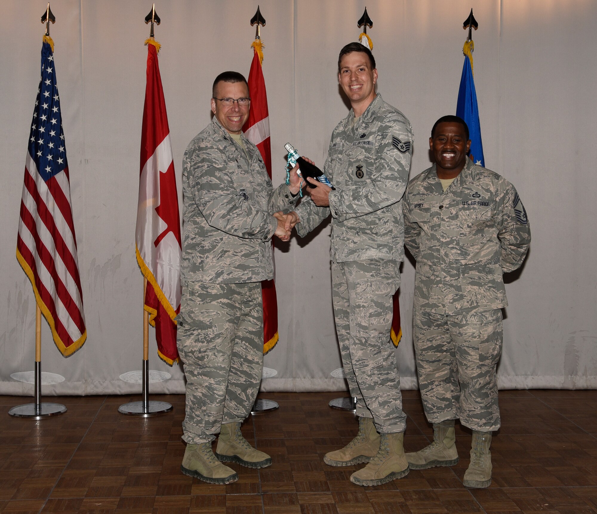 Col. Timothy Bos, 821st Air Base Group commander, left, and Chief Master Sgt. Lee Utsey, 821st ABG superintendent, congratulate Staff Sgt. David Cuff, 821st Security Forces Squadron bravo team lead, middle, during his notification of promotion to technical sergeant at Thule Air Base, Greenland, July 19, 2019. Cuff was officially notified of his promotion selection when he was on paternity leave. (U.S. Air Force photo by Staff Sgt. Alexandra M. Longfellow)