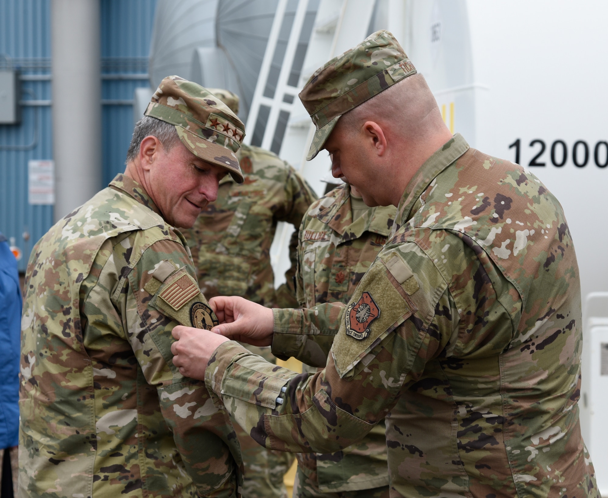 Master Sgt. Timothy Tichawa, 821st Air Base Group member, placed a 12th Space Warning Squadron patch on the Air Force Chief of Staff General David Goldfein’s uniform during a site visit to Thule Air Base, Greenland, July 20, 2019. The squadron is one of three Ballistic Missile Early Warning System radar stations which collectively track satellites, missiles and other objects moving in the airspace above the North Pole. (U.S. Air Force photo by Staff Sgt. Alexandra M. Longfellow)