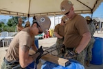 A U.S. Navy Seabee measures rebar.