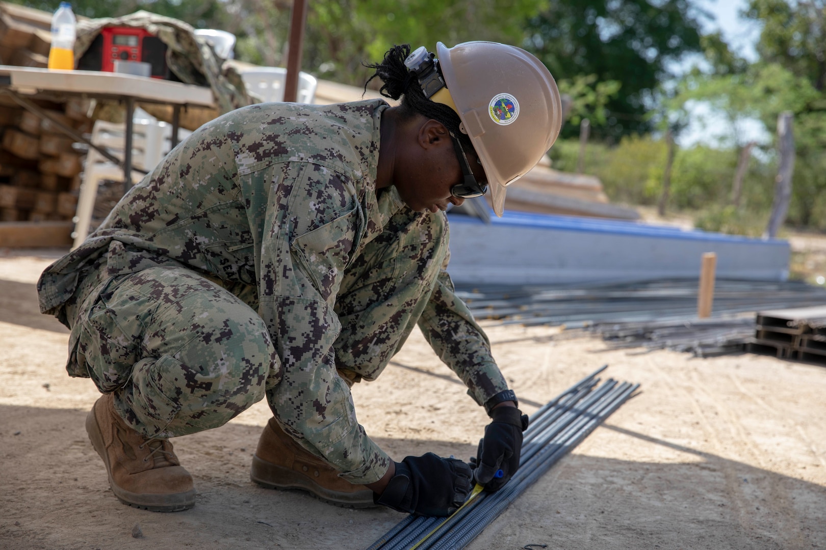 A U.S. Navy Seabee measures rebar.