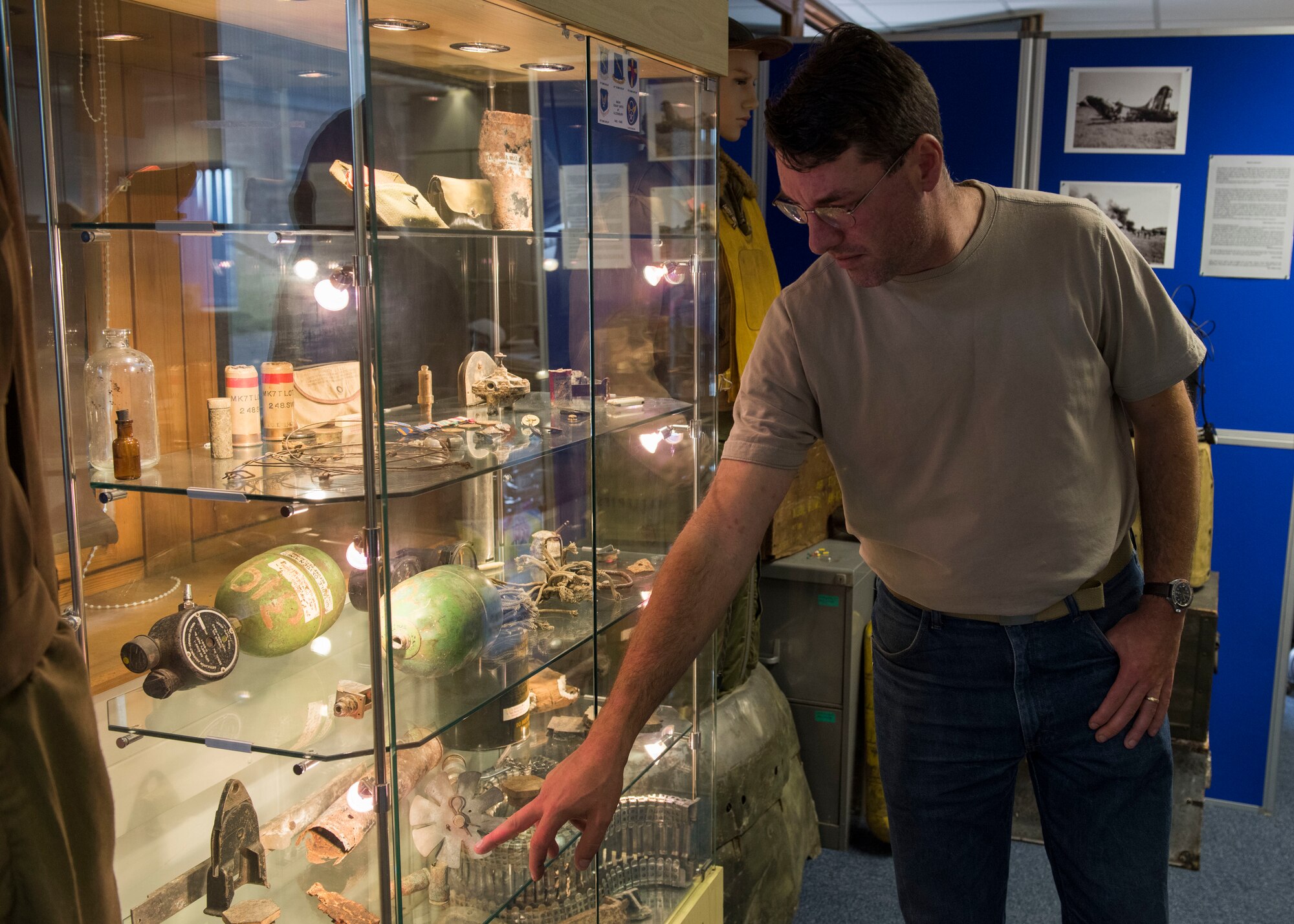 Paul George Bellamy, Airfield Research Group director of archives and collections, points to World War II-era cases at the Alconbury Airfield Heritage Collection, England, July 14, 2019. The 20mm cases were discovered in the dirt on the flight line. (U.S. Air Force photo by Airman 1st Class Jennifer Zima)