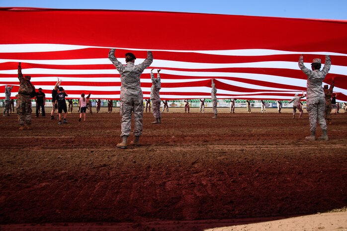 Hill Air Force Base Airmen alongside other military members and first responders serving in Utah unfurl an American flag during Patriot Night at the Ogden Pioneer Days Rodeo in Ogden, Utah, July 22, 2019.