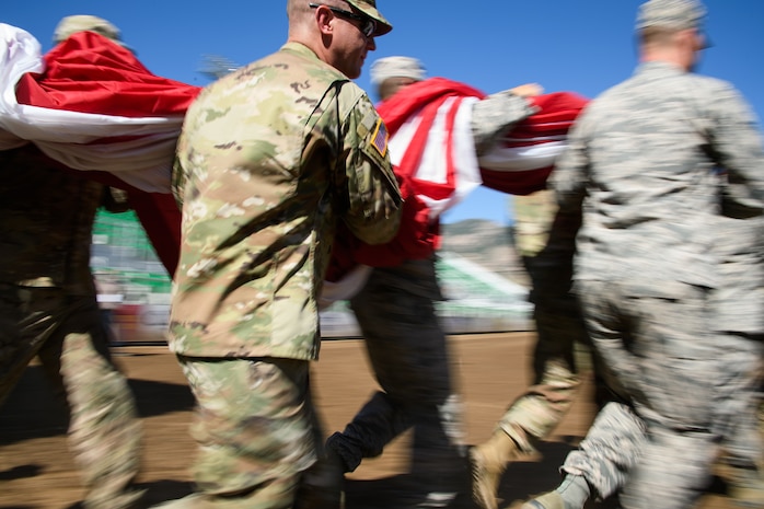 Hill Air Force Base Airmen alongside other military members and first responders serving in Utah carry an American flag during Patriot Night at the Ogden Pioneer Days Rodeo in Ogden, Utah, July 22, 2019.