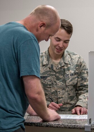 Senior Airman John Demko, 49th Comptroller Squadron financial operations technician, explains the spouse licensure reimbursement program to a customer, July 30, 2019, at the finance office on Holloman Air Force Base, N.M. On May 13, 2019, the Air Force implemented a licensure reimbursement program, not to exceed $500, for dependent spouses who require a relicensure or recertification during a permanent change of station or assignment across state lines. (U.S. Air Force photo by Airman 1st Class Kindra Stewart)