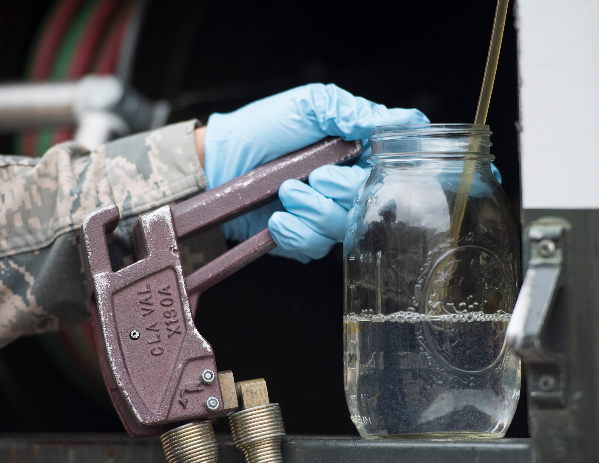 U.S. Air Force Tech. Sgt. Dustin Legatt, a fuels specialist with the 133rd Petroleum, Oil and Lubricants Flight, collects a sample to determine the amount free water within the JET-A fuel in St. Paul, Minn., July 10, 2019.